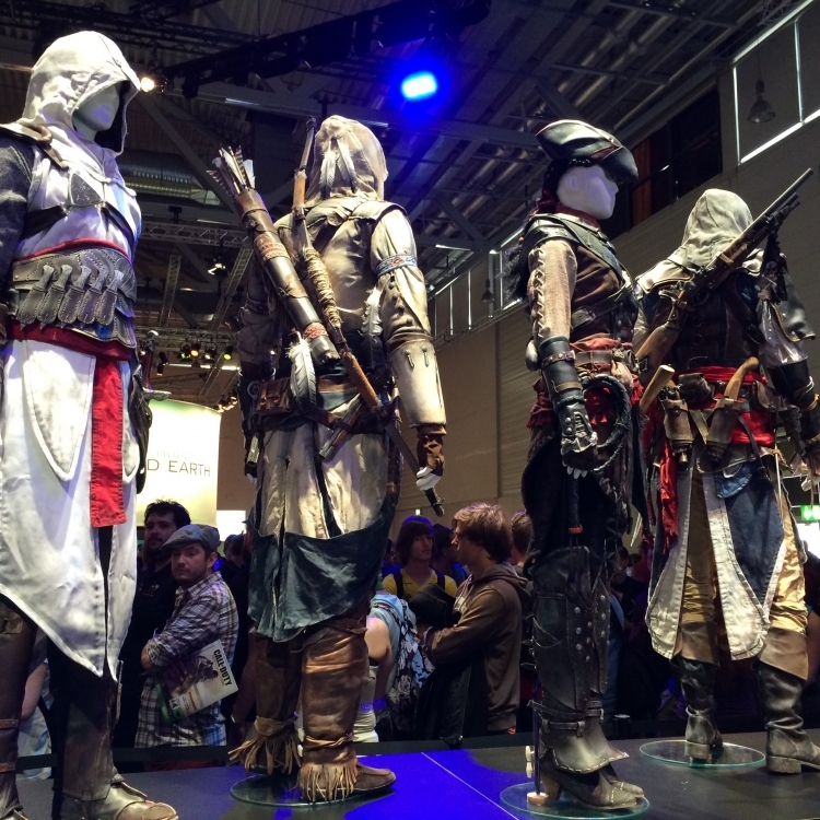 Assassin Statues on display near the Assassin's Creed: Unity and Rogue booths.